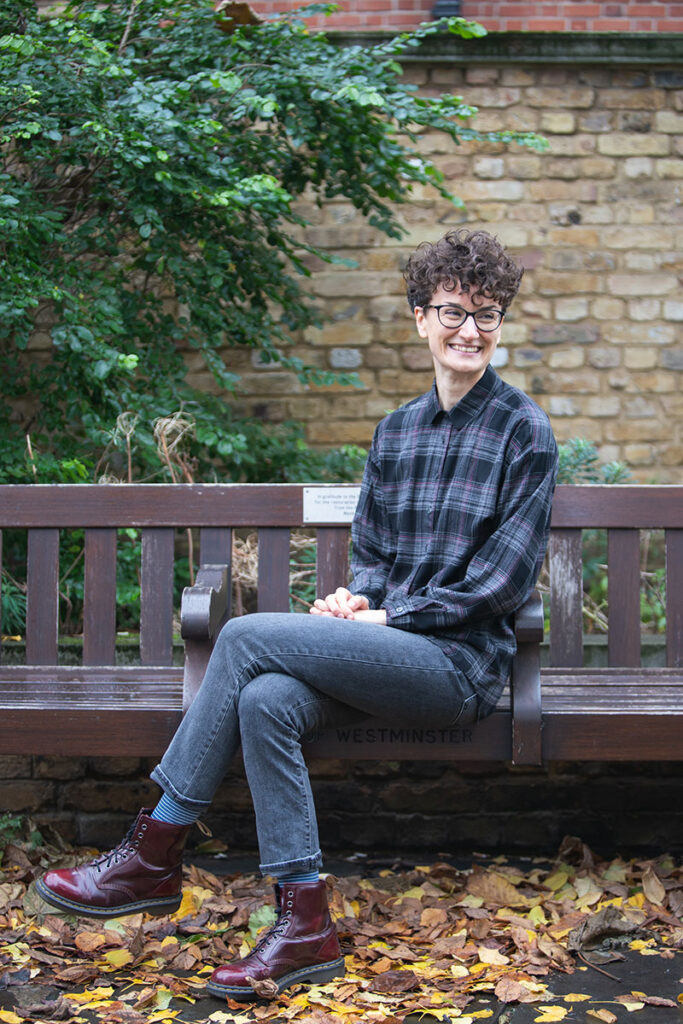 Music expert and broadcaster Flora Willson is standing in a pedestrian tunnel in an urban environment